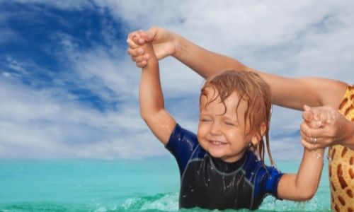 παιδι στην θαλασσα μαθαινει να κολυμπαει